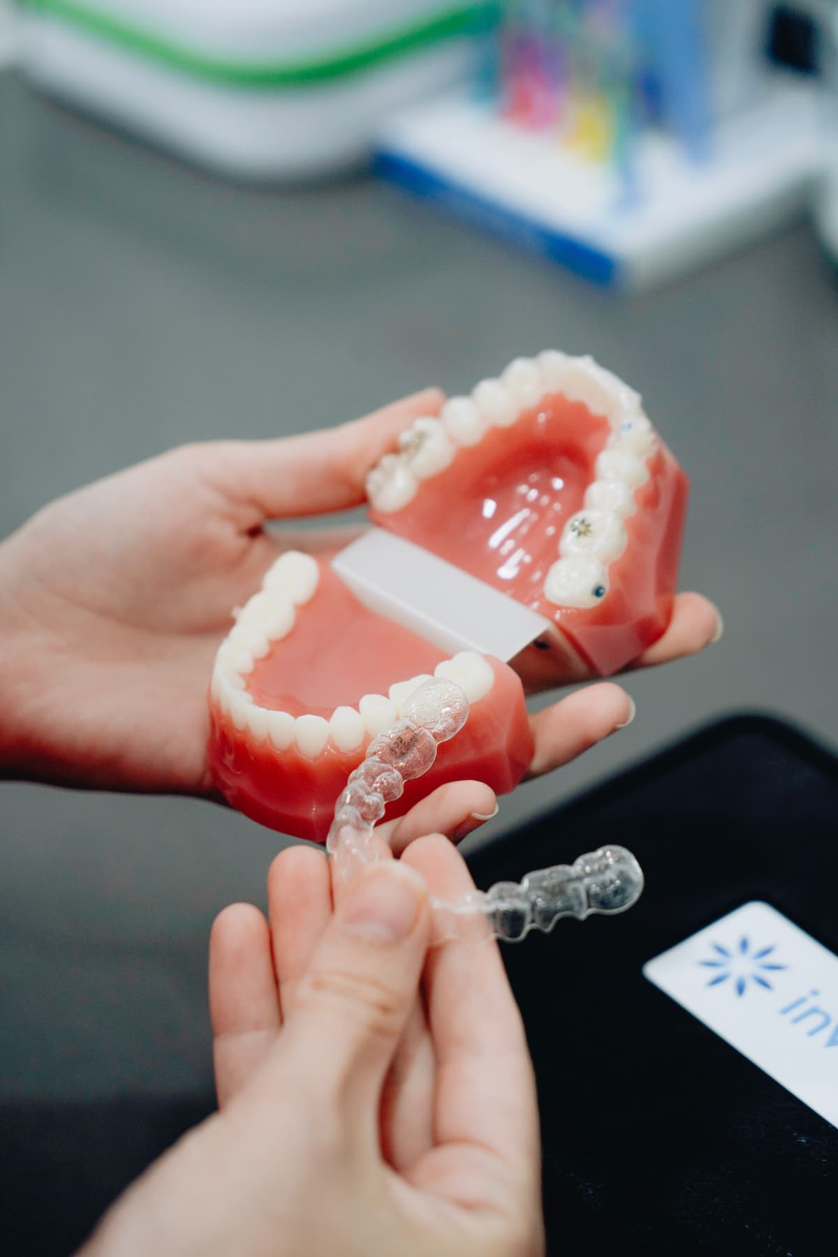 Hands holding dental models and clear invisalign